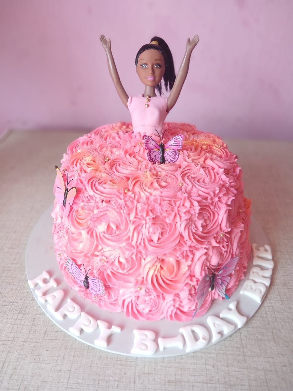 Pink rosette doll cake with butterflies
