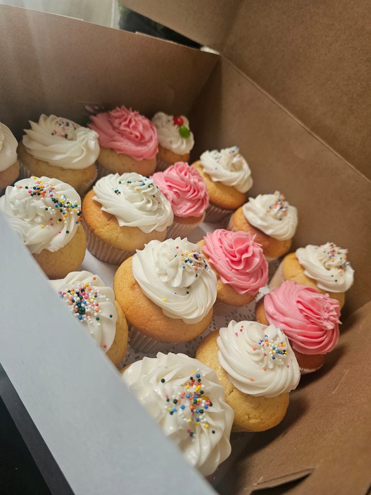Vanilla cupcakes decorated with pink and white buttercream and sprinkles
