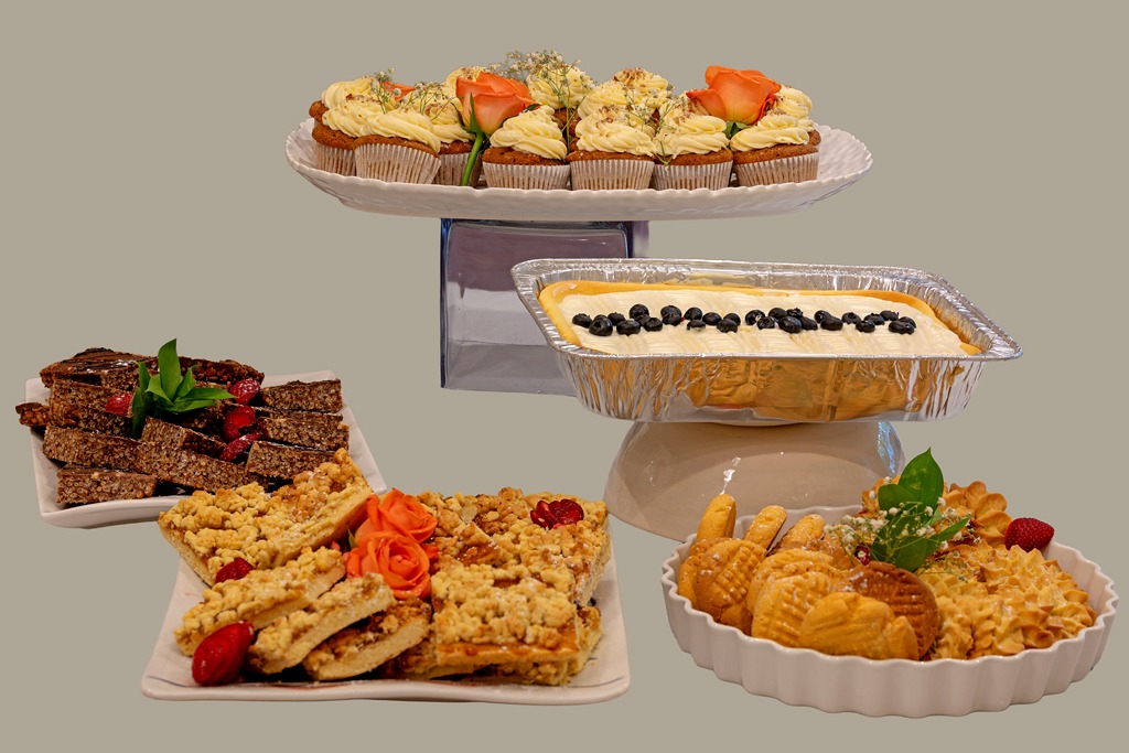 A tiered display of cupcakes, cheesecake, crumble squares, chocolate slices and biscuits